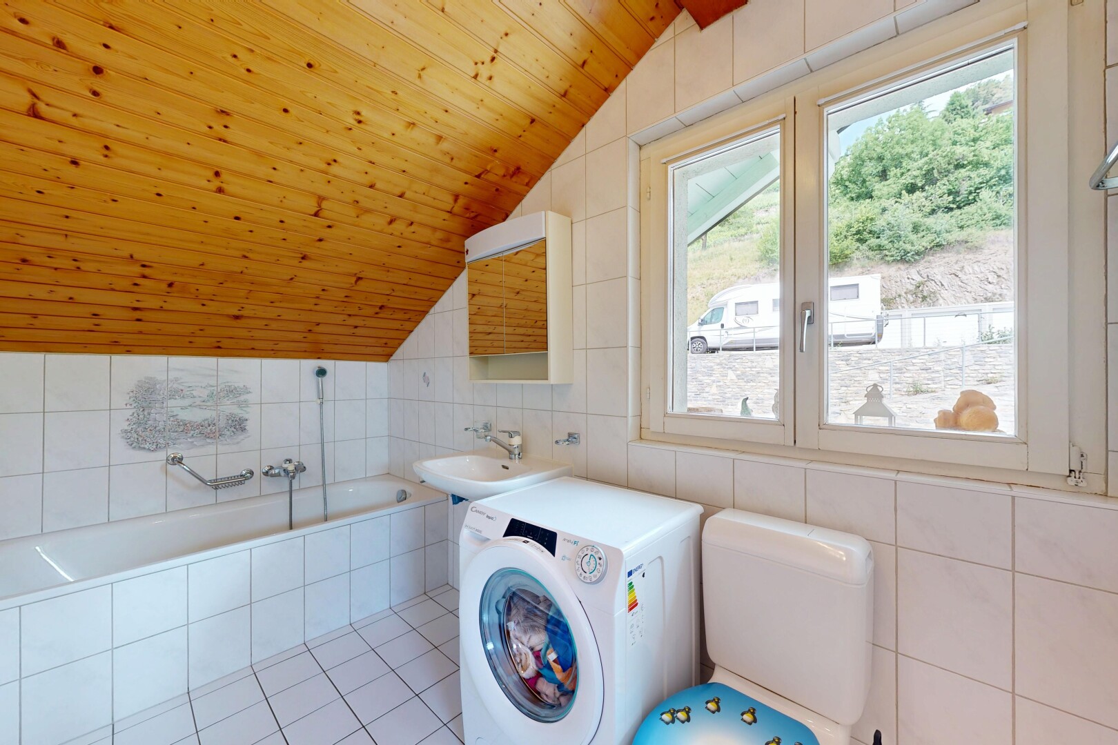 buanderie avec lave-linge et sèche-linge, mur en carrelage, tile wall, plafond voûté, et vaulted ceiling