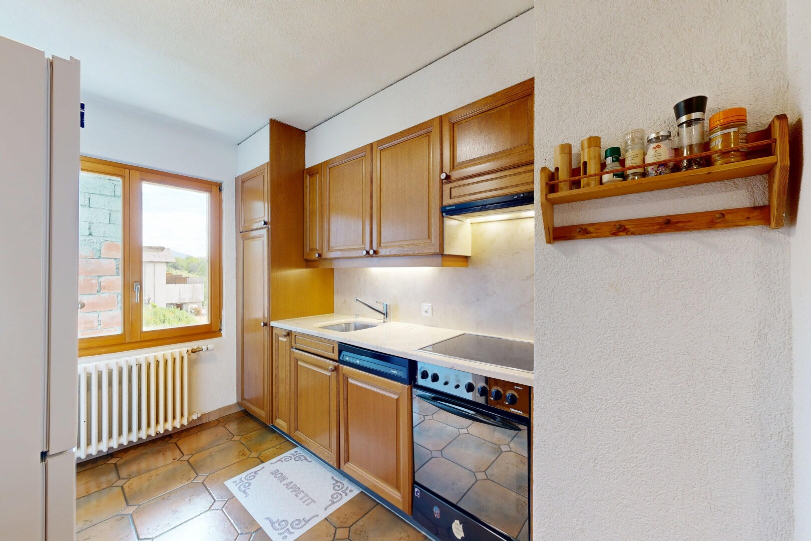 cuisine avec four, réfrigérateur, radiateur, plans de travail, et light countertops