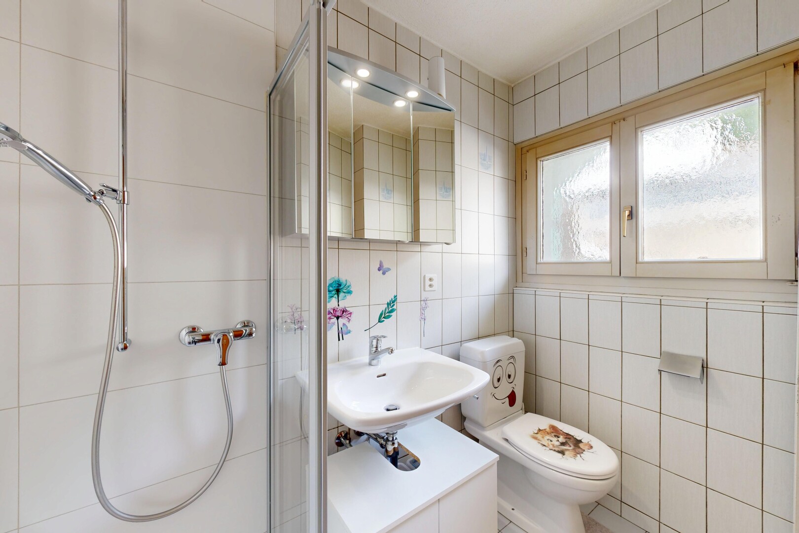 salle de bains avec miroir, tile wall, mur en carrelage, douche, et salle de bain complète