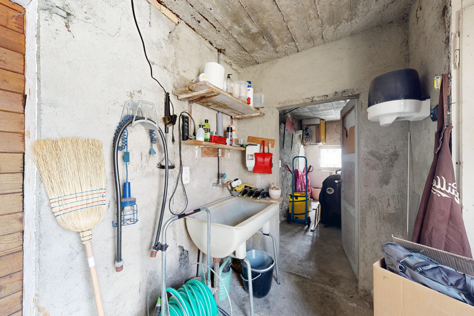 cuisine avec concrete floor, sol en béton, inside property, évier, et concrete wall