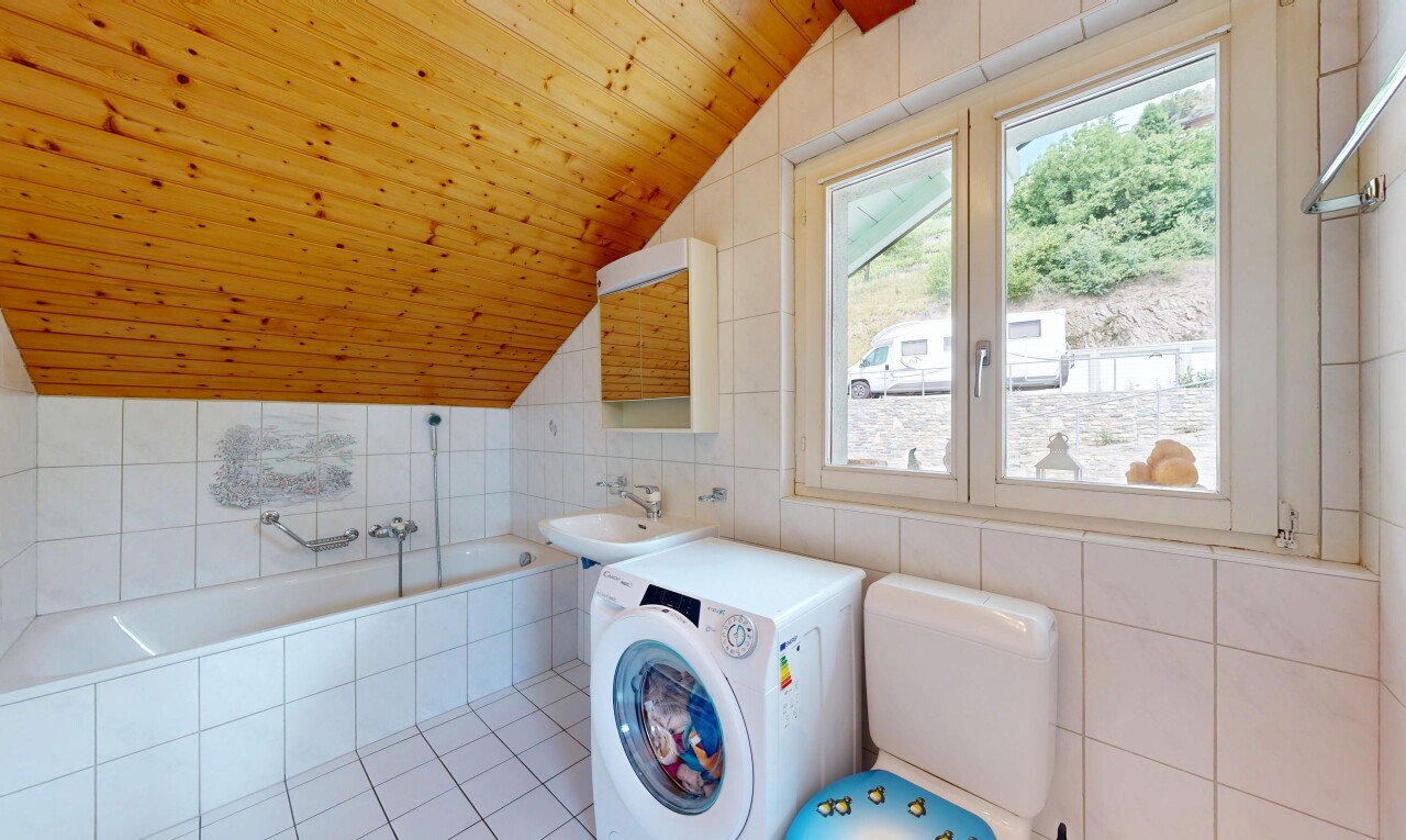 buanderie avec lave-linge et sèche-linge, mur en carrelage, tile wall, plafond voûté, et vaulted ceiling