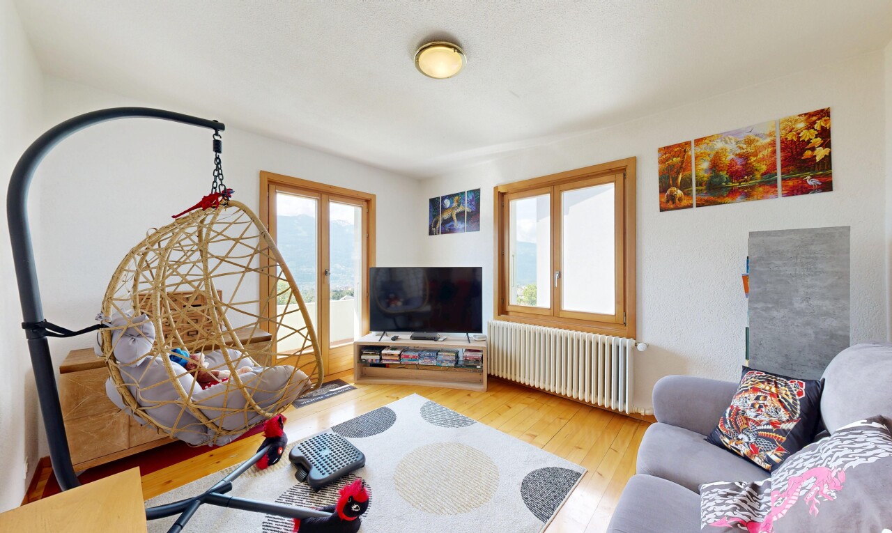 salon avec sol en finition bois, wood finish floor, radiateur, télévision, et inside property