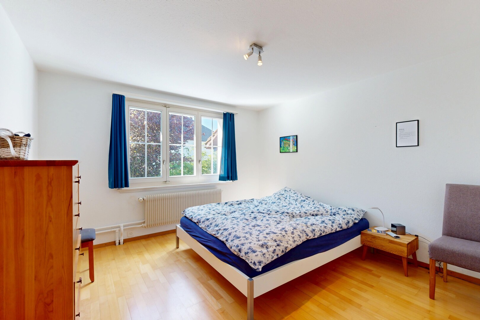 chambre avec inside property, radiateur, sol en finition bois, wood finish floor, et lumière naturelle
