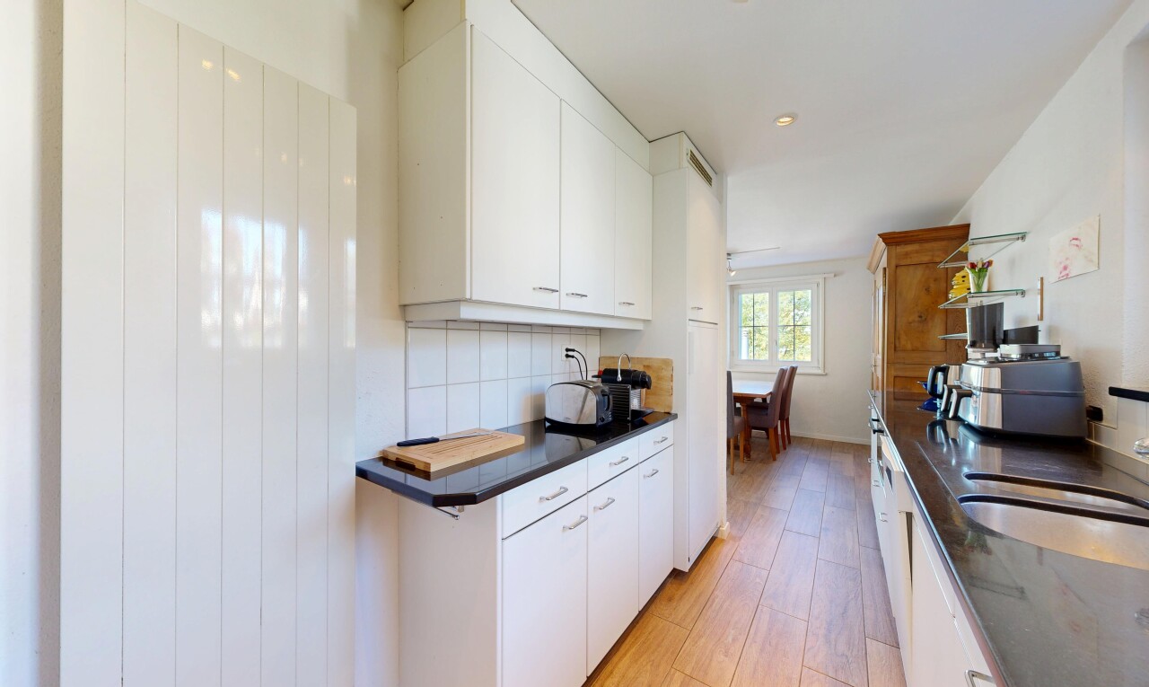 cuisine avec plans de travail, dark countertops, dosseret, backsplash, et light floor