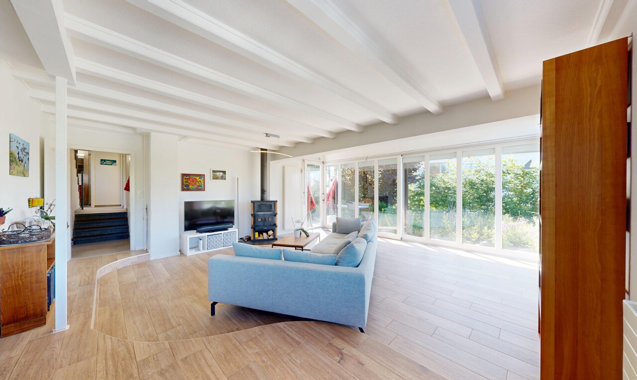 salon avec inside property, poêle à bois, cloison sèche, drywall, et sol en finition bois