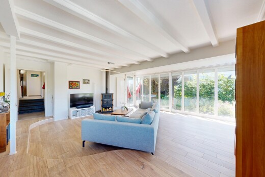wohnzimmer mit inside property, holzofen, gipskartonwand, drywall, und holzfußboden