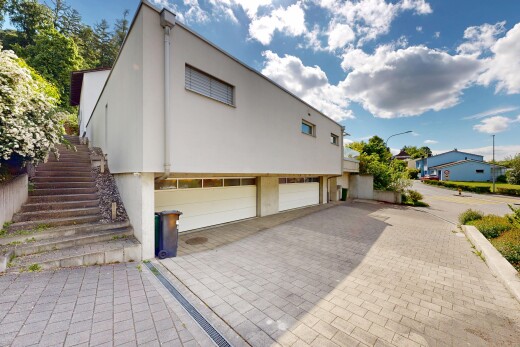 außenansicht mit treppen, eingebaute garage, auffahrt, stuckverkleidung, und day time