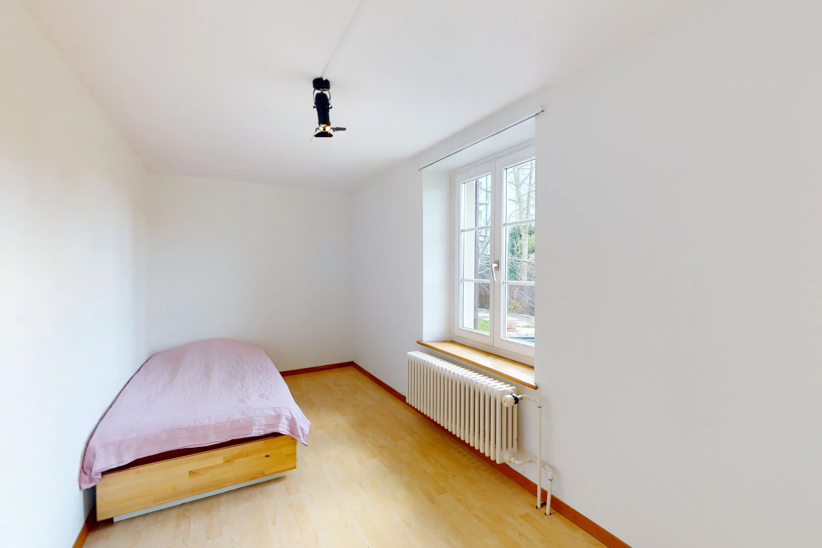 chambre à coucher avec parquet, lumière naturelle, et radiateur