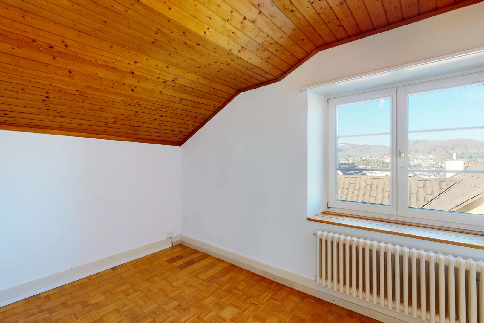 chambre bonus avec parquet, plafond voûté, lumière naturelle, et radiateur