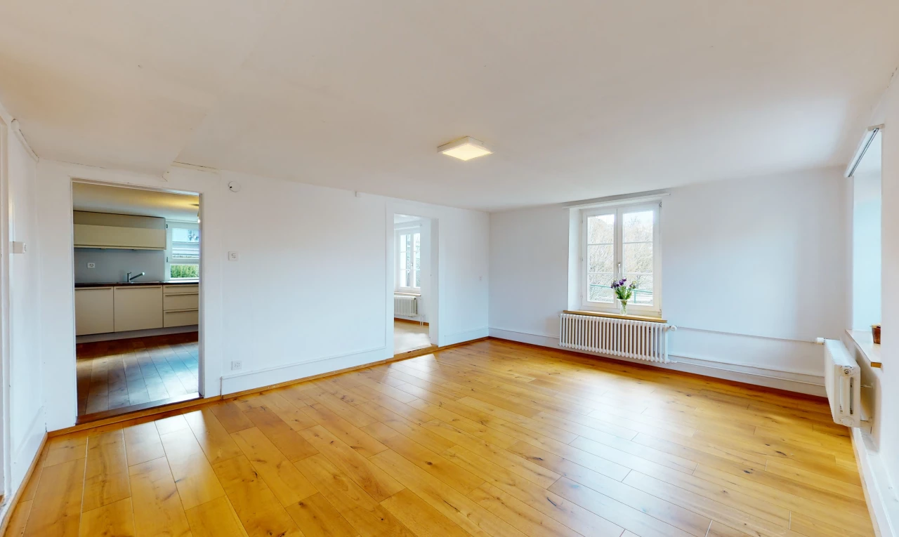 chambre vide avec parquet, lumière naturelle, et radiateur