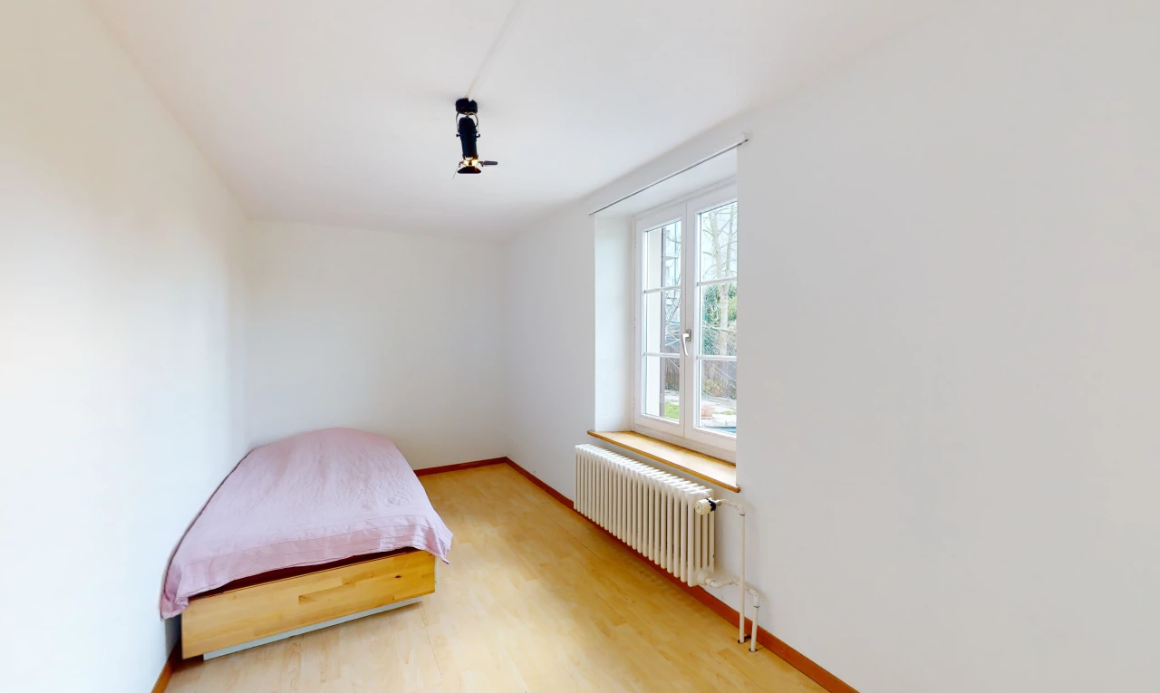 chambre à coucher avec parquet, lumière naturelle, et radiateur