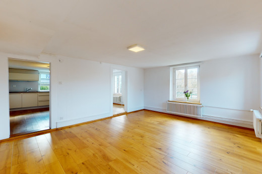 chambre vide avec parquet, lumière naturelle, et radiateur