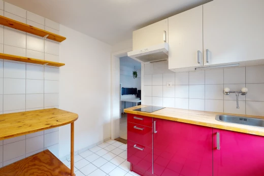 cuisine avec carrelage, cuisinière électrique, hotte, sol clair, plan de travail clair, et meubles blancs