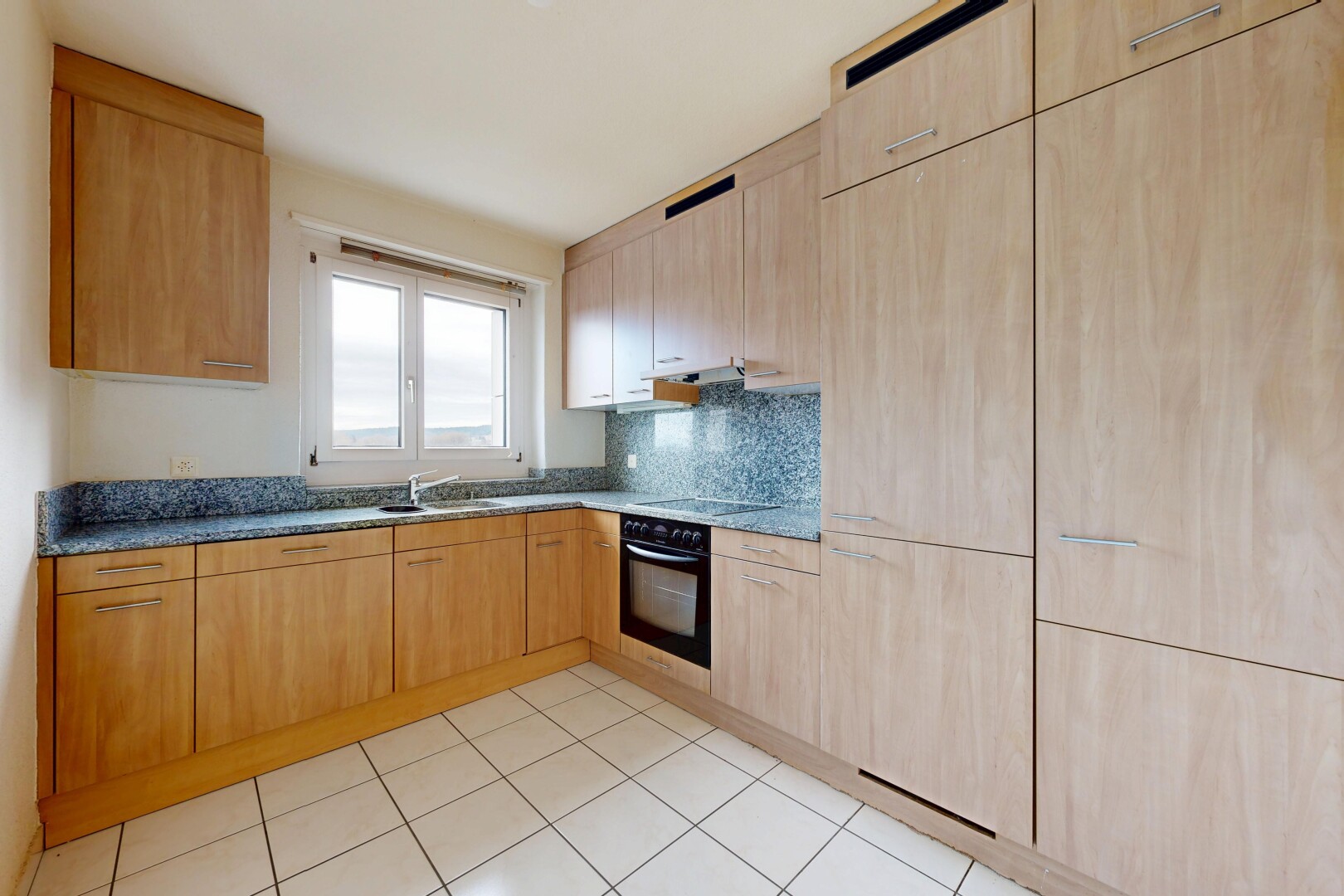 kitchen featuring light wood finish cabinets, black appliances, tasteful backsplash, and light tile patterned floors