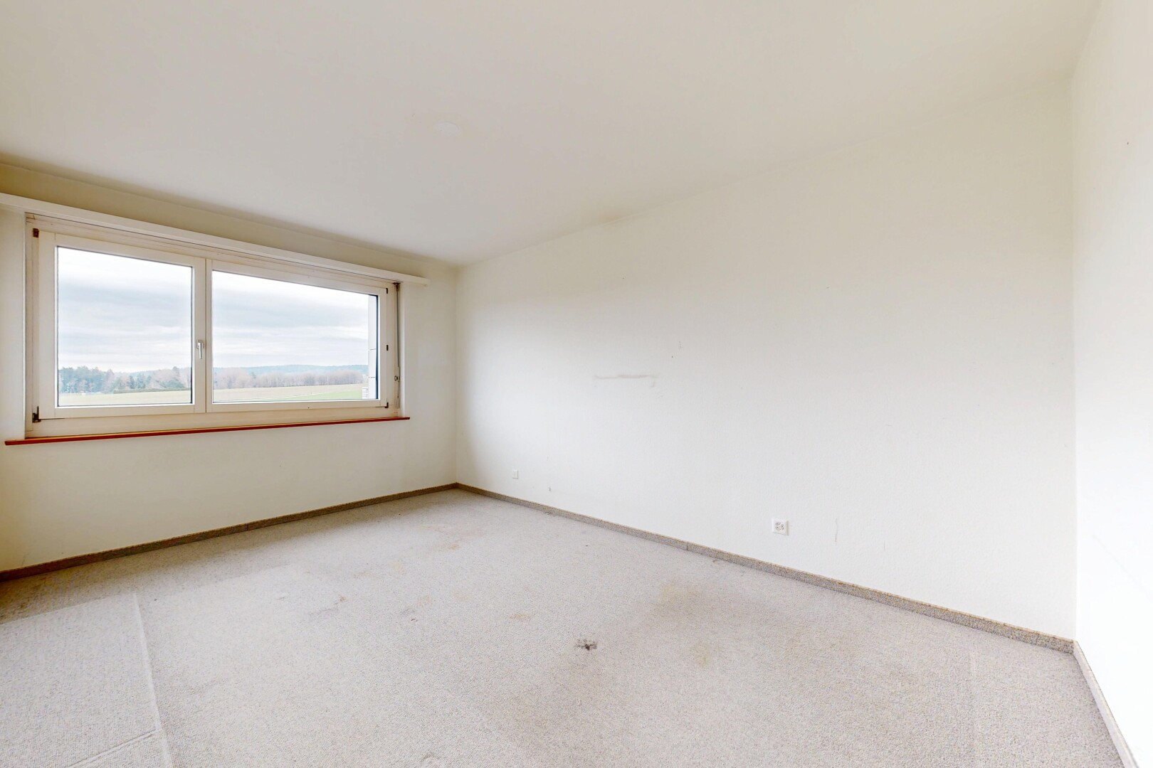 unfurnished room featuring light carpet and baseboards