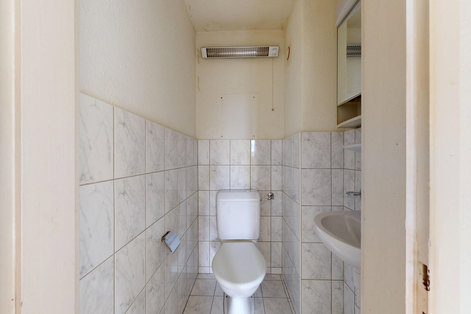 half bath with tile walls and tile patterned flooring