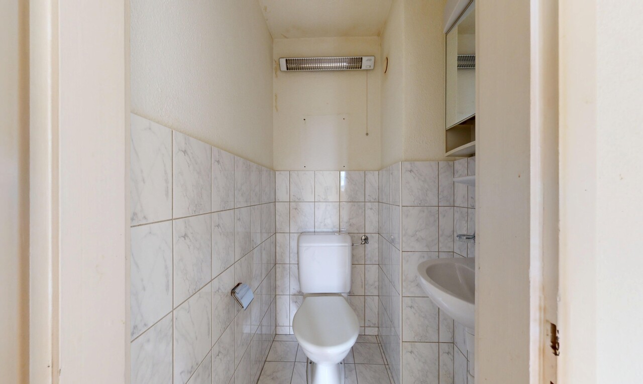 half bath with tile walls and tile patterned flooring