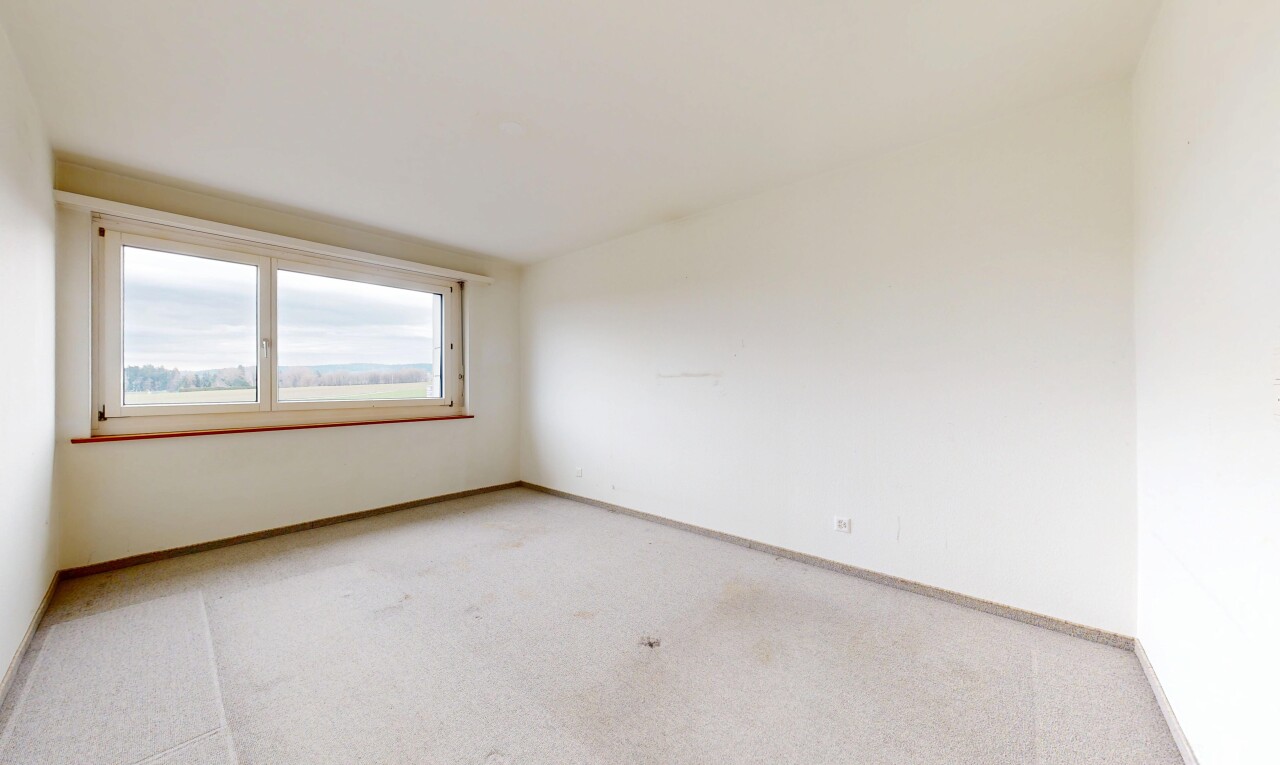 unfurnished room featuring light carpet and baseboards