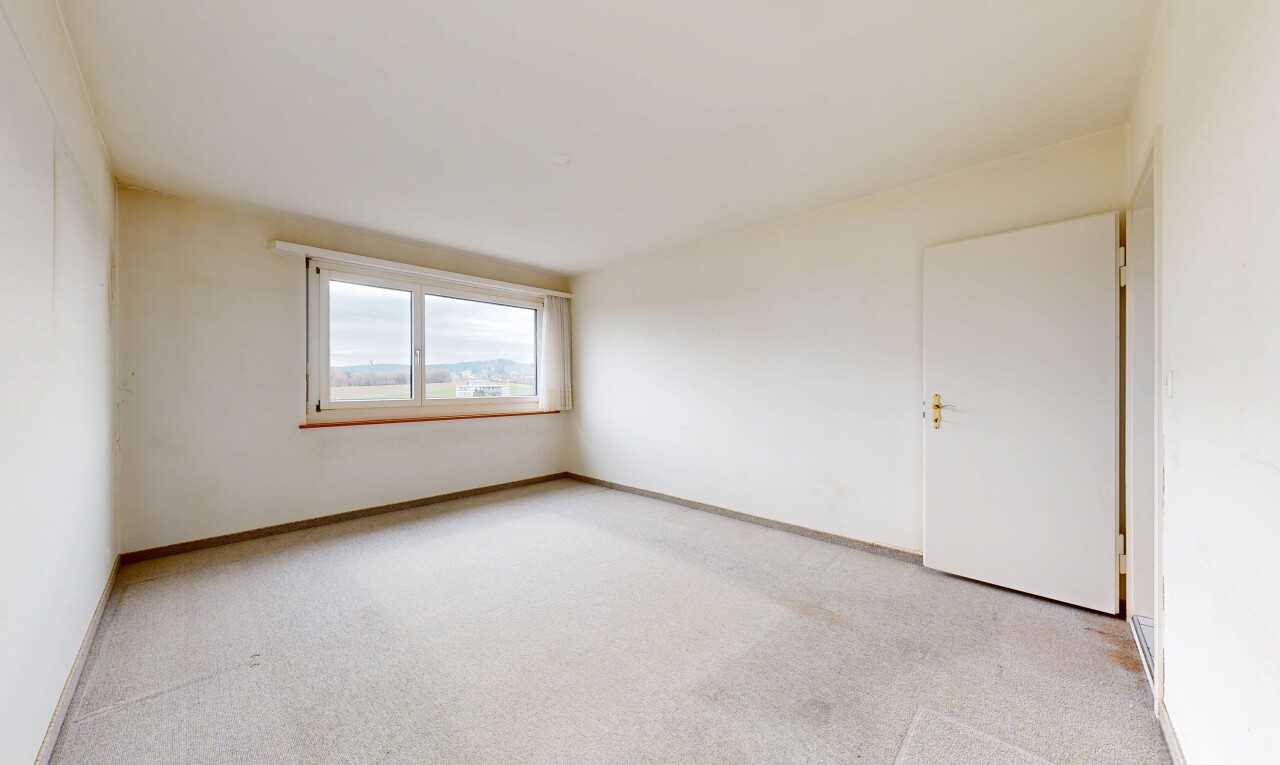unfurnished room featuring light carpet and baseboards