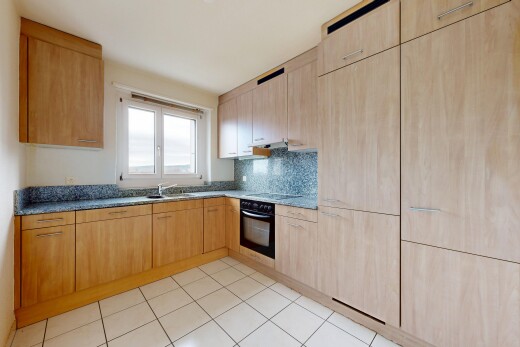 cuisine avec armoires marron clair, light brown cabinets, light floor, four, et lumière naturelle