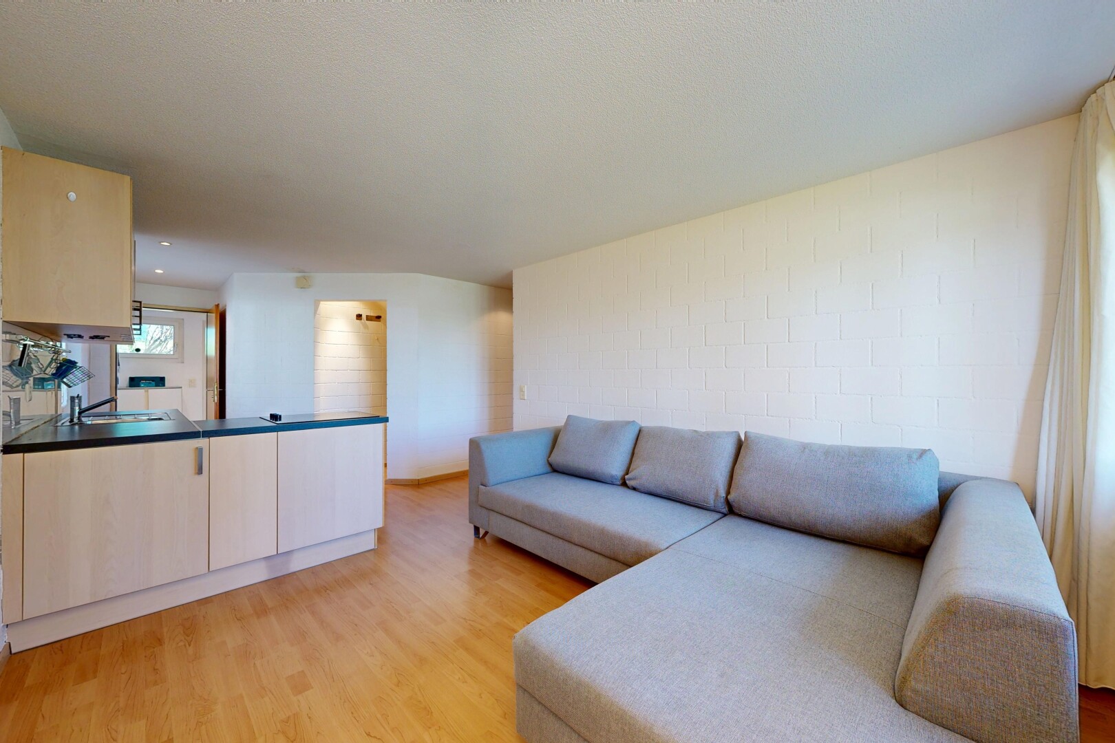 salon avec sol en finition bois, wood finish floor, light floor, inside property, et lumière naturelle