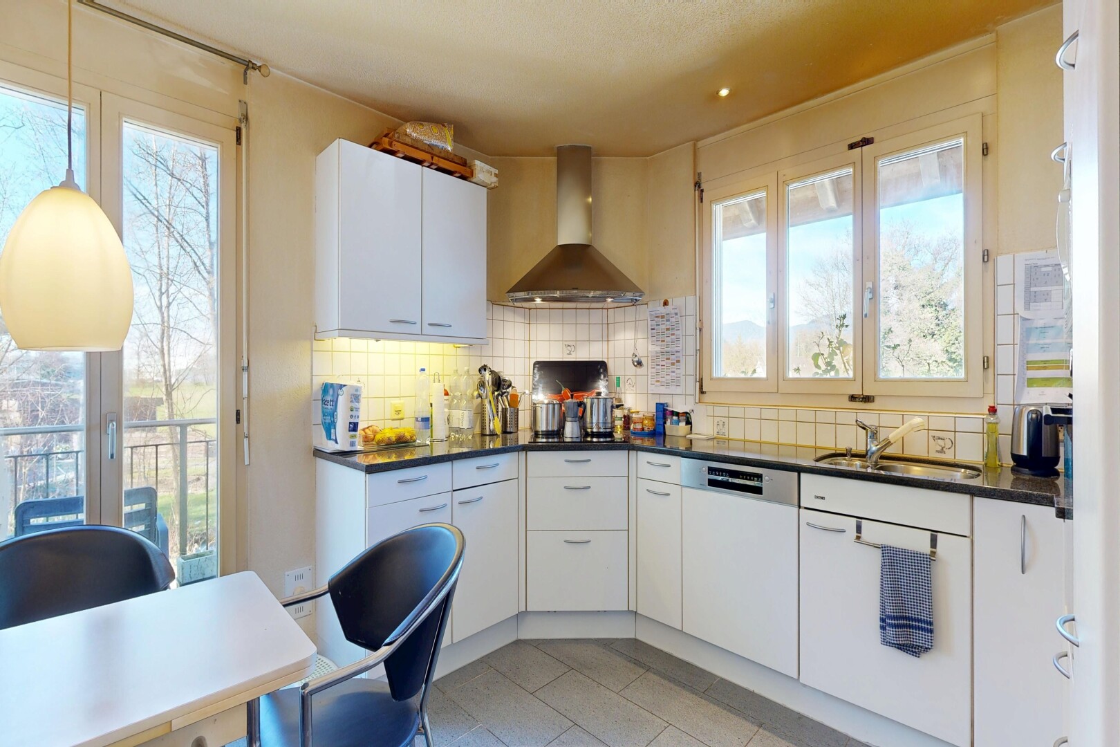 cuisine avec hotte, dark countertops, plans de travail, pendant lighting, et éclairage suspendu