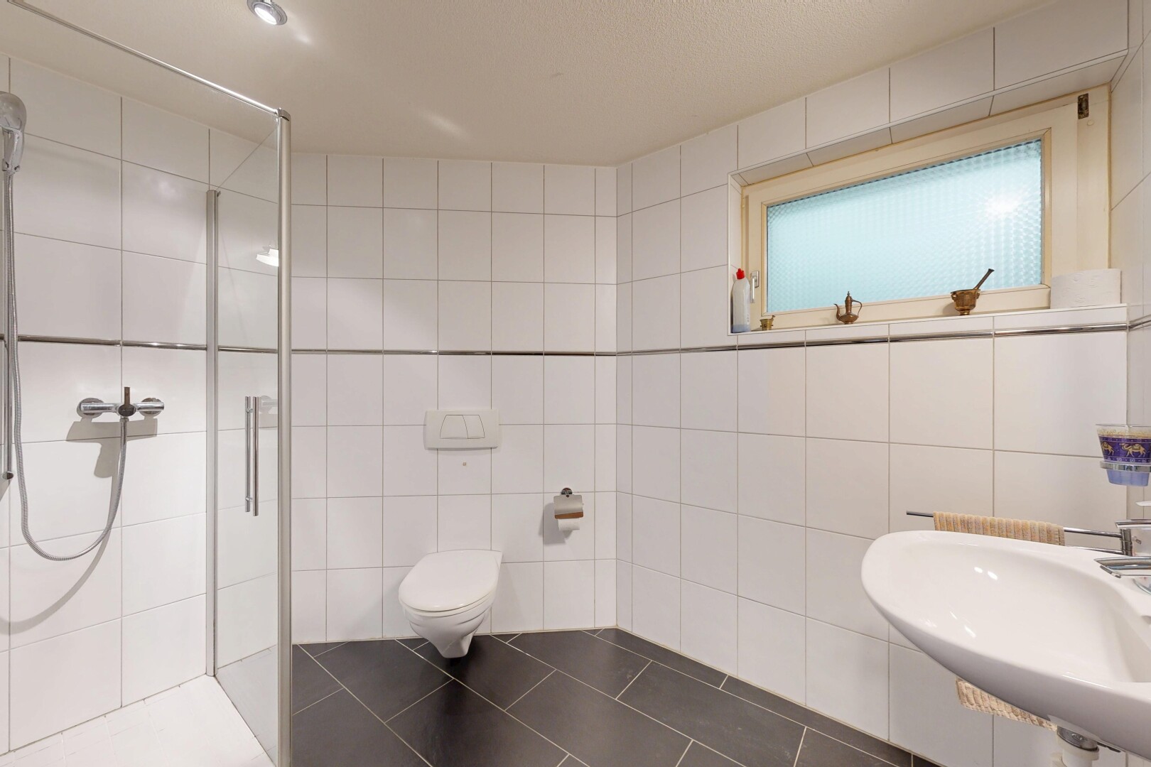 salle de bains avec mur en carrelage, tile wall, douche, salle de bain complète, et évier