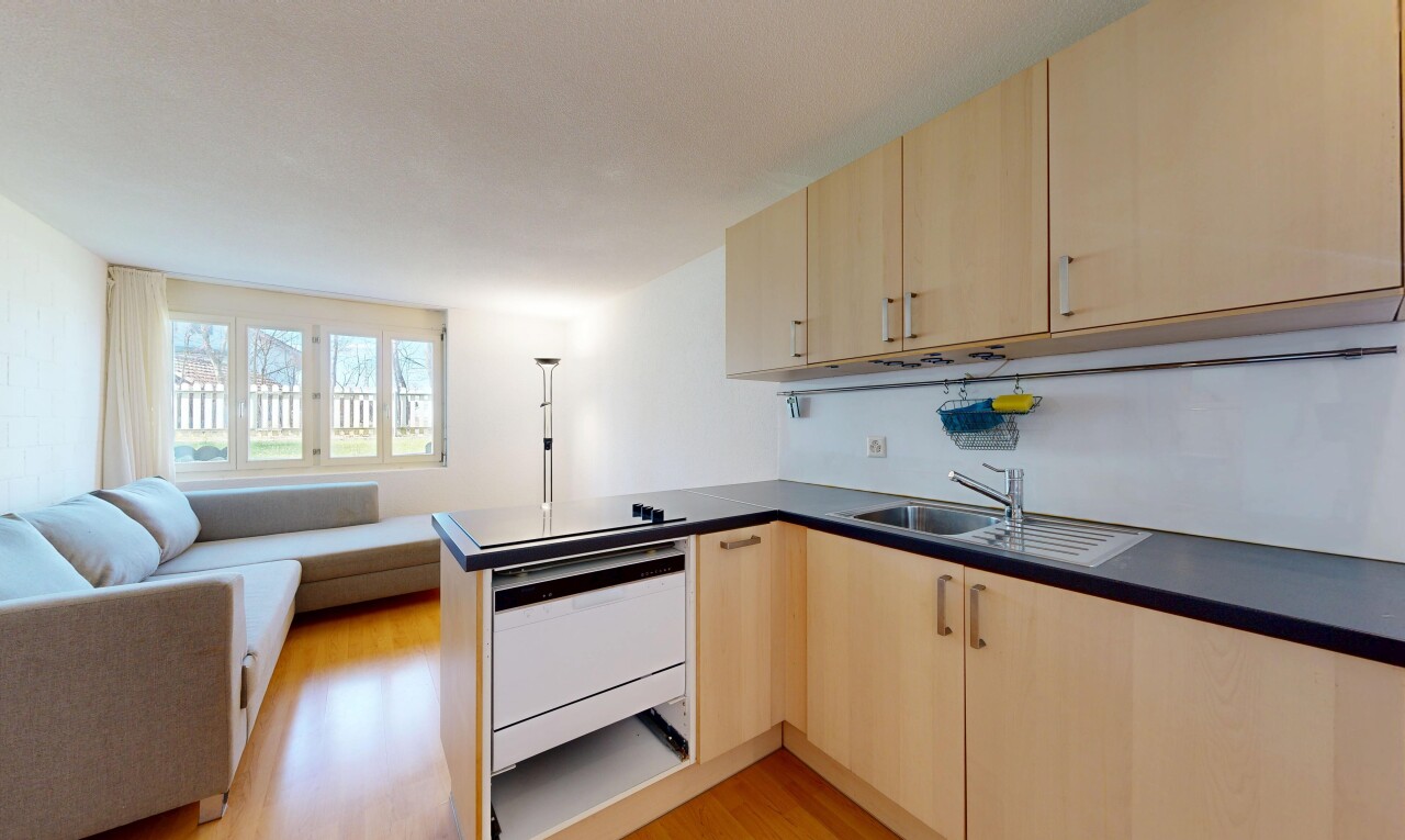 cuisine avec armoires marron clair, light brown cabinets, sol en finition bois, wood finish floor, et ouvert sur l'espace de vie
