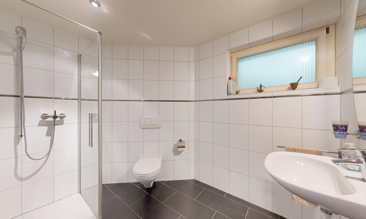 salle de bains avec mur en carrelage, tile wall, douche, salle de bain complète, et évier