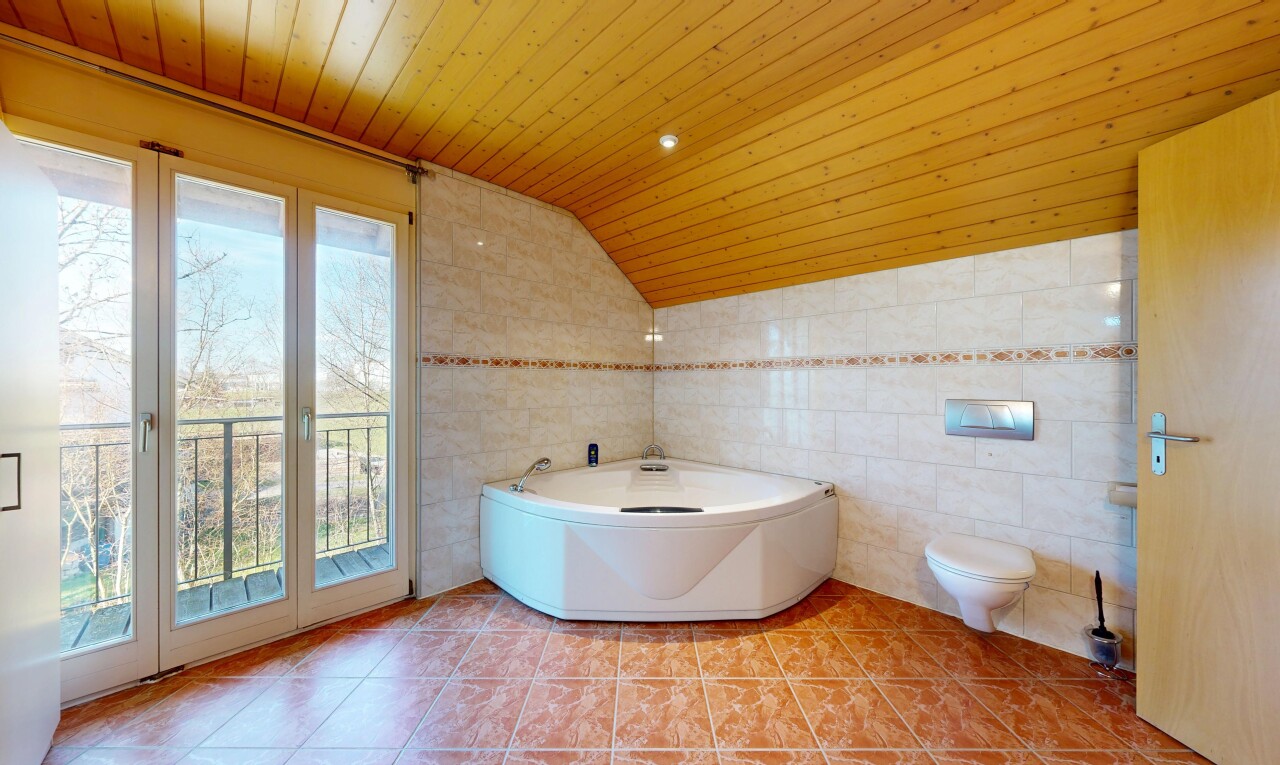 salle de bains avec salle de bain complète, vaulted ceiling, plafond voûté, tile wall, et mur en carrelage