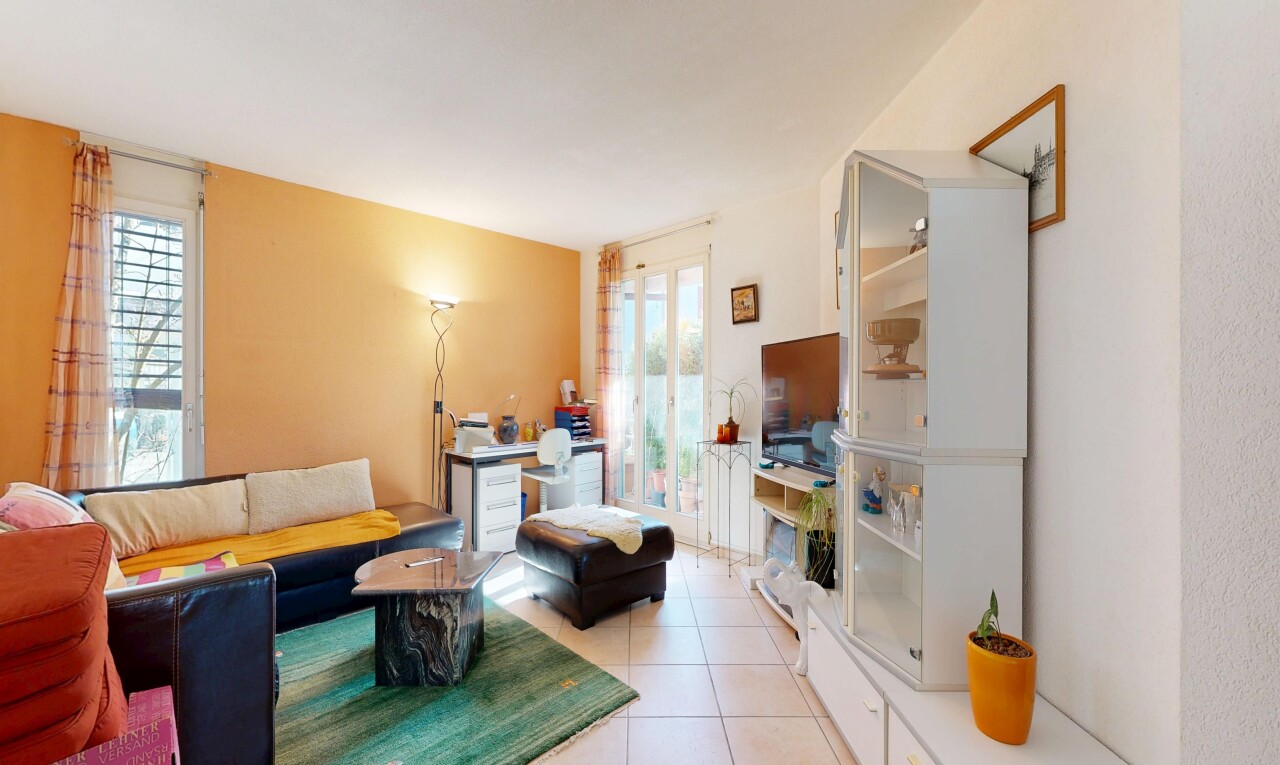 salon avec inside property, télévision, cloison sèche, drywall, et sol en carrelage