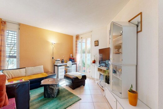 salon avec inside property, télévision, cloison sèche, drywall, et sol en carrelage