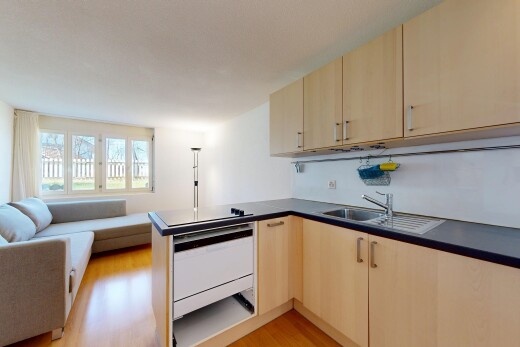 cuisine avec armoires marron clair, light brown cabinets, sol en finition bois, wood finish floor, et ouvert sur l'espace de vie