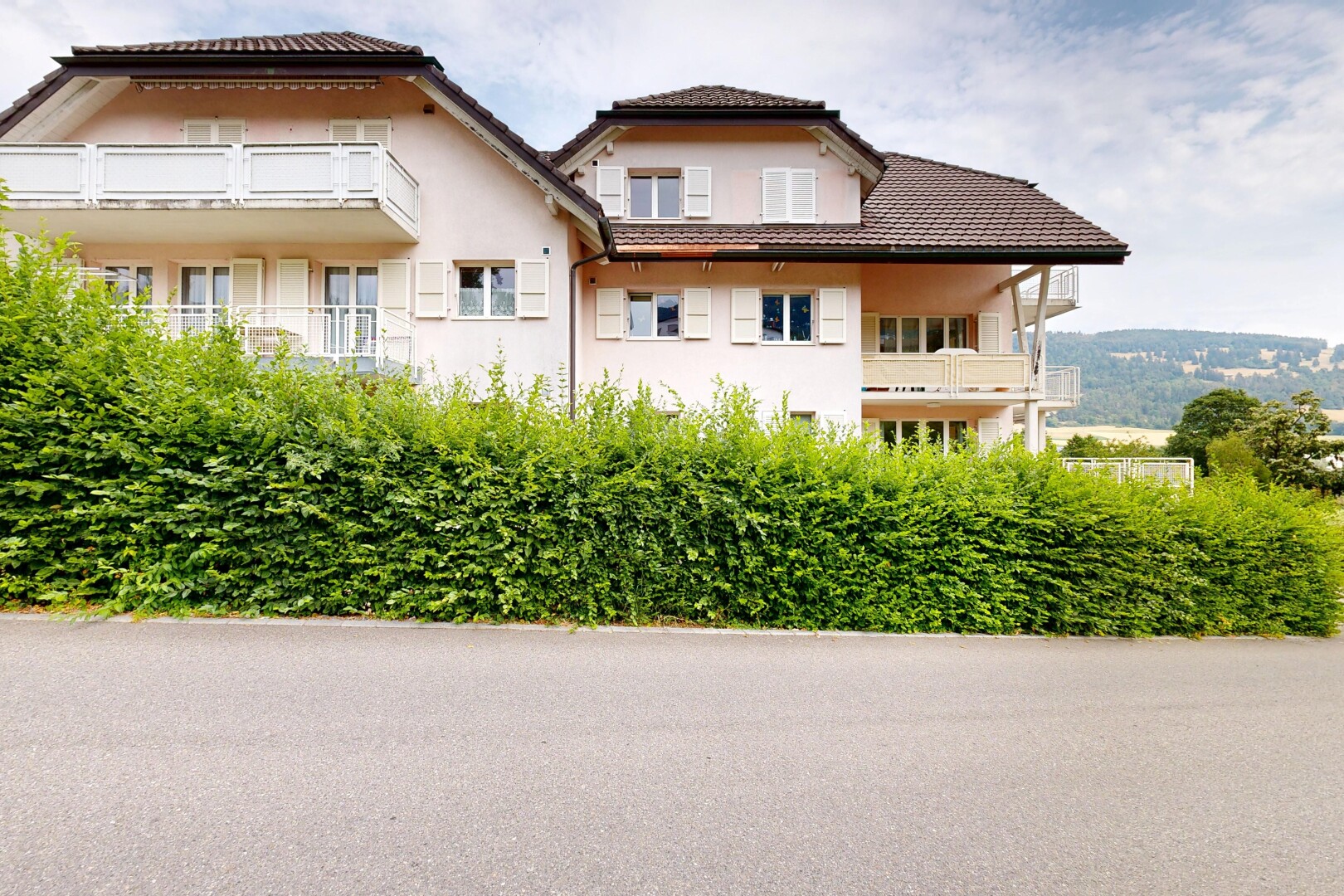 façade avec balcon, toit en tuiles, bardage en stuc, et day time