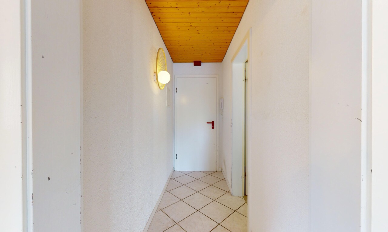 couloir avec inside property, wood ceiling, plafond en bois, tile floor, et sol en carrelage