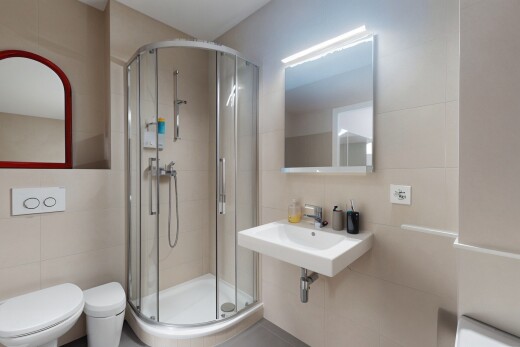 salle de bains avec mur en carrelage, tile wall, miroir, toilette, et douche