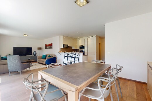 wohn- / esszimmer mit fernseher, holzfußboden, wood finish floor, gipskartonwand, und drywall