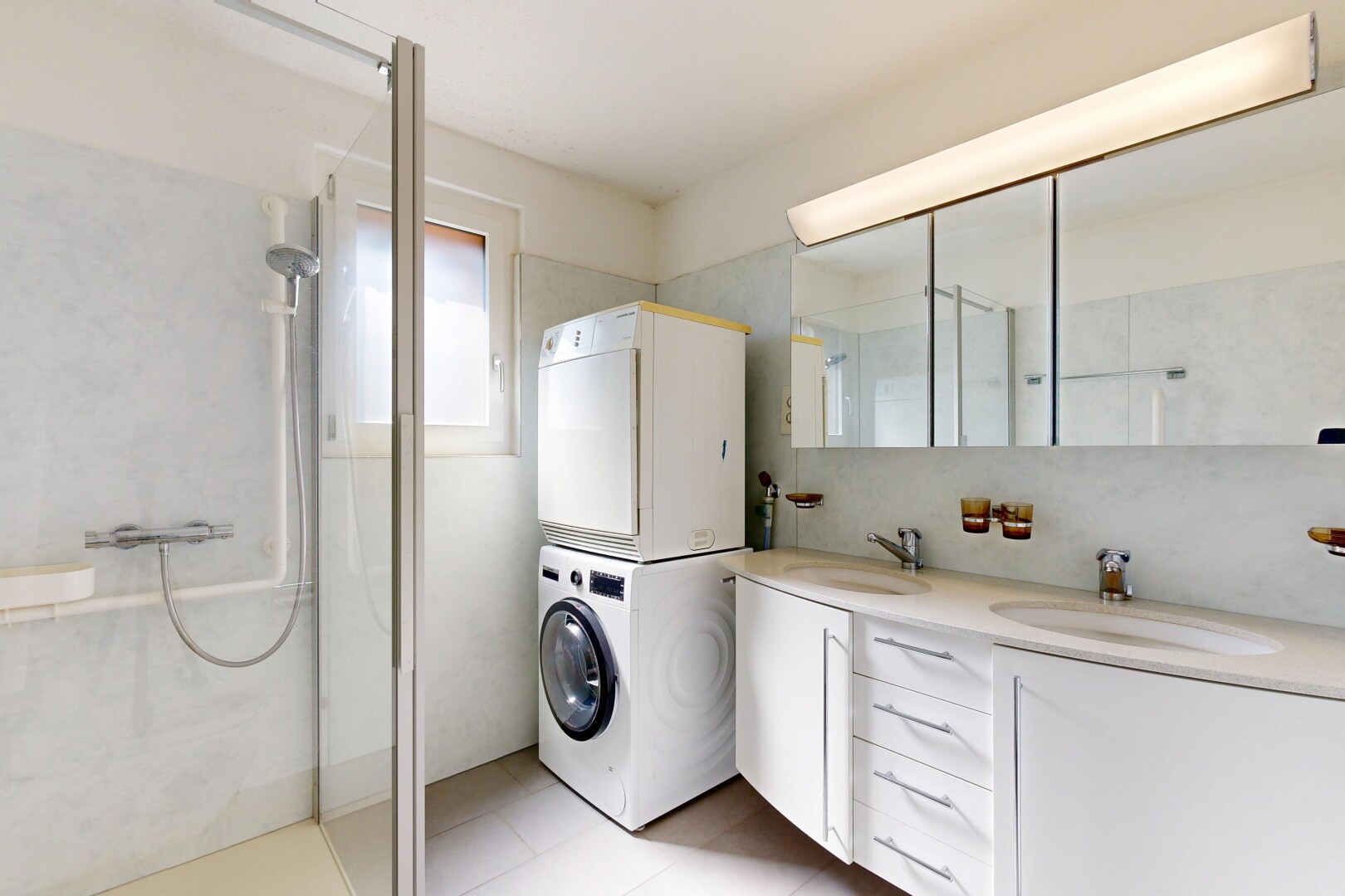 buanderie avec buanderie, light floor, évier, inside property, et lave-linge et sèche-linge superposés