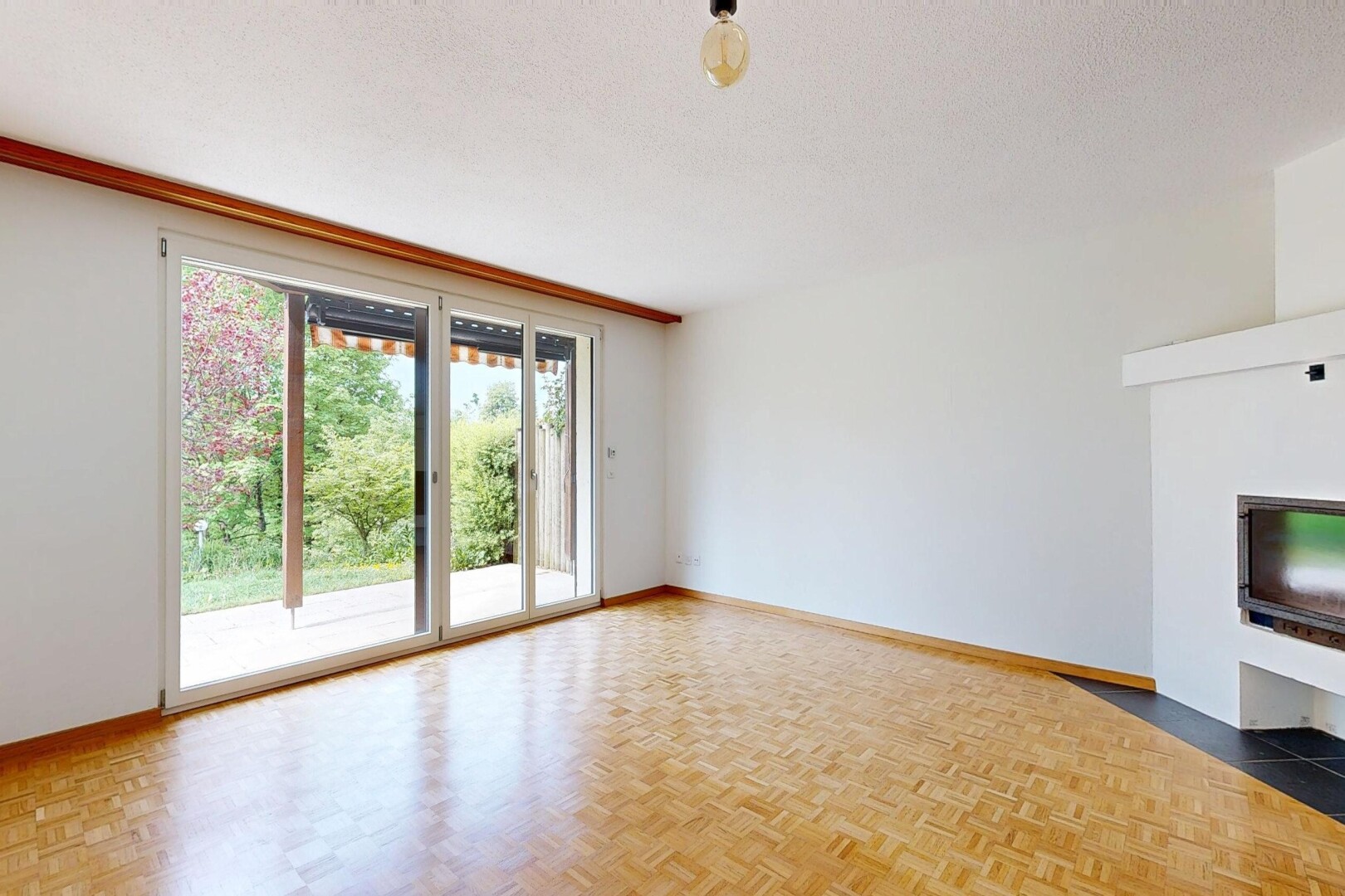pièce vide avec cheminée, sol en finition bois, wood finish floor, cloison sèche, et drywall