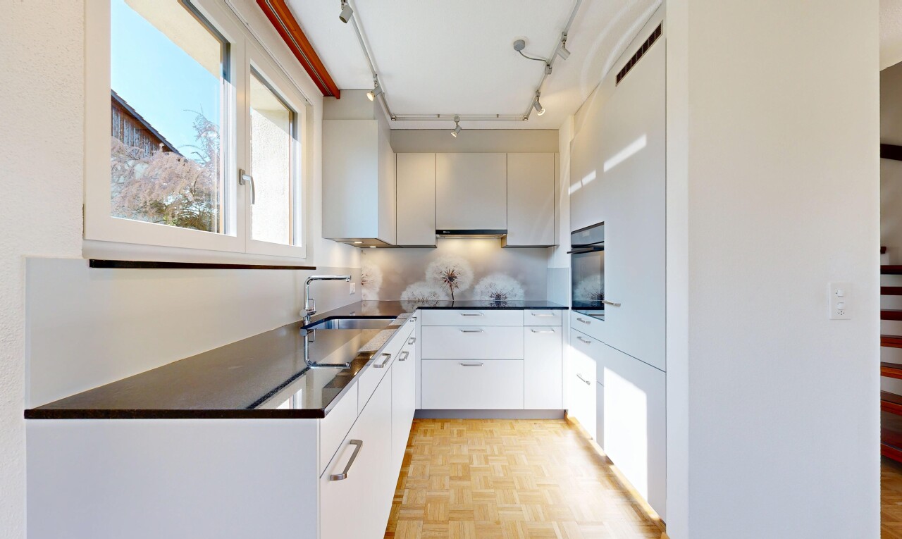 cuisine avec plans de travail, dark countertops, parquet floor, sol en finition bois, et wood finish floor