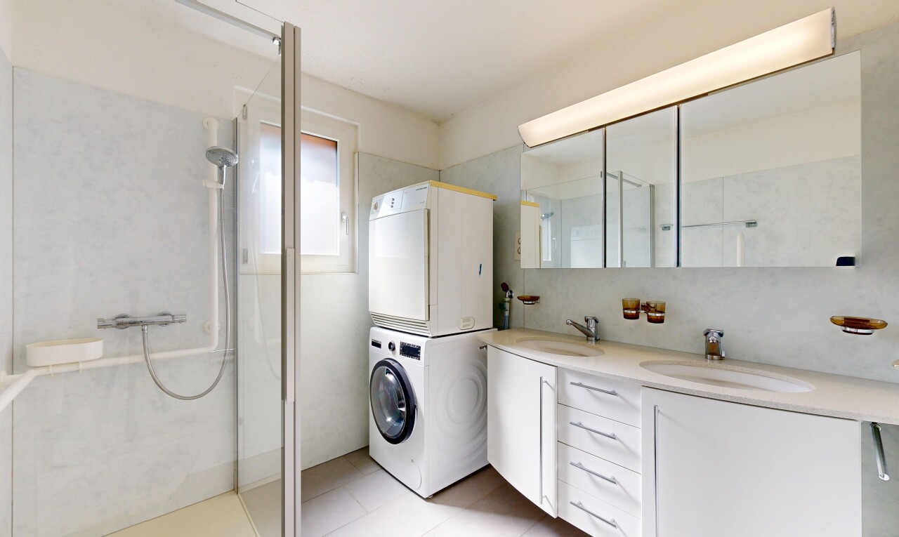 buanderie avec buanderie, light floor, évier, inside property, et lave-linge et sèche-linge superposés