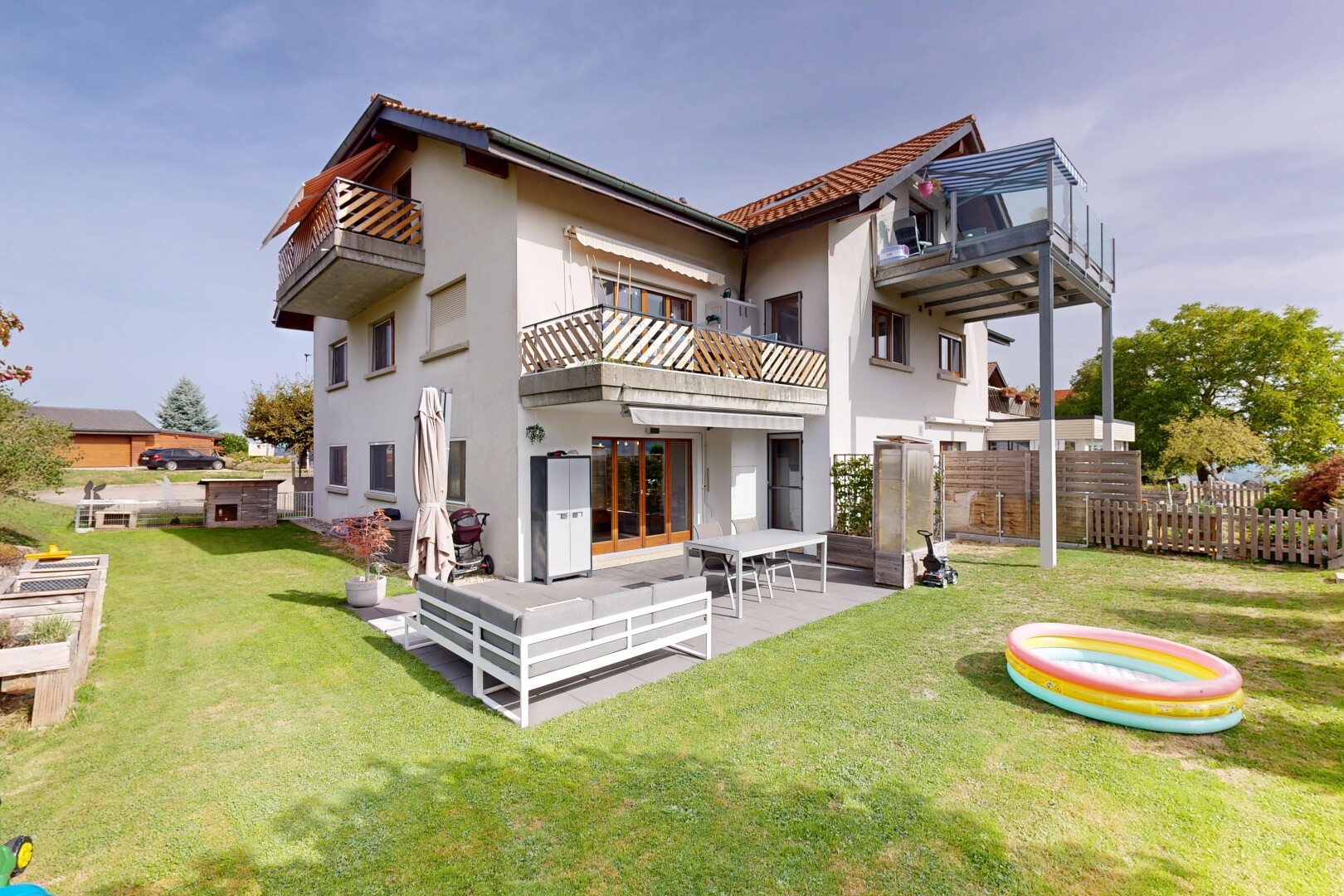 außenansicht mit rasen, property visible, zaun, balkon, und stuckverkleidung