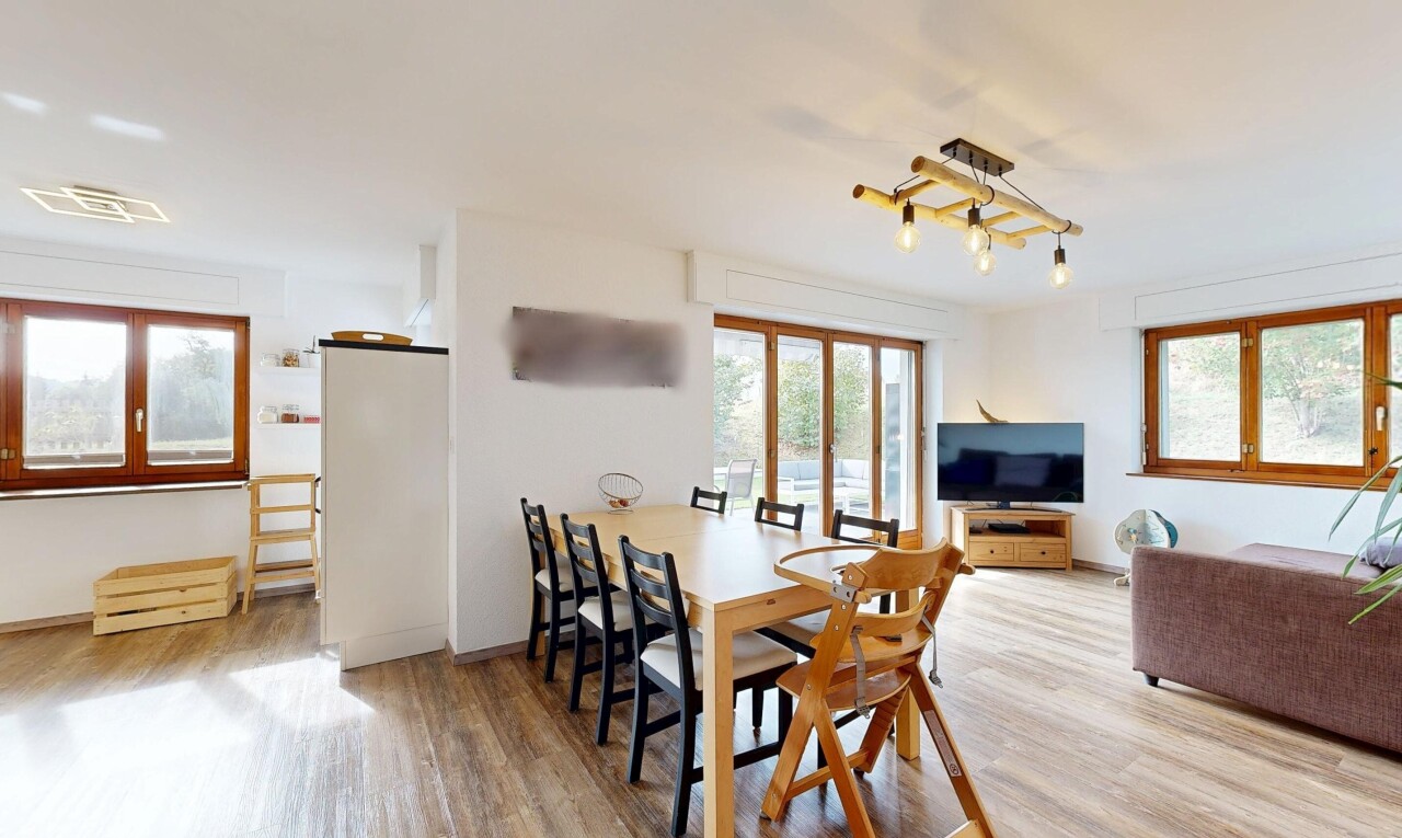 wohn- / esszimmer mit drywall, gipskartonwand, fernseher, wood finish floor, und holzfußboden