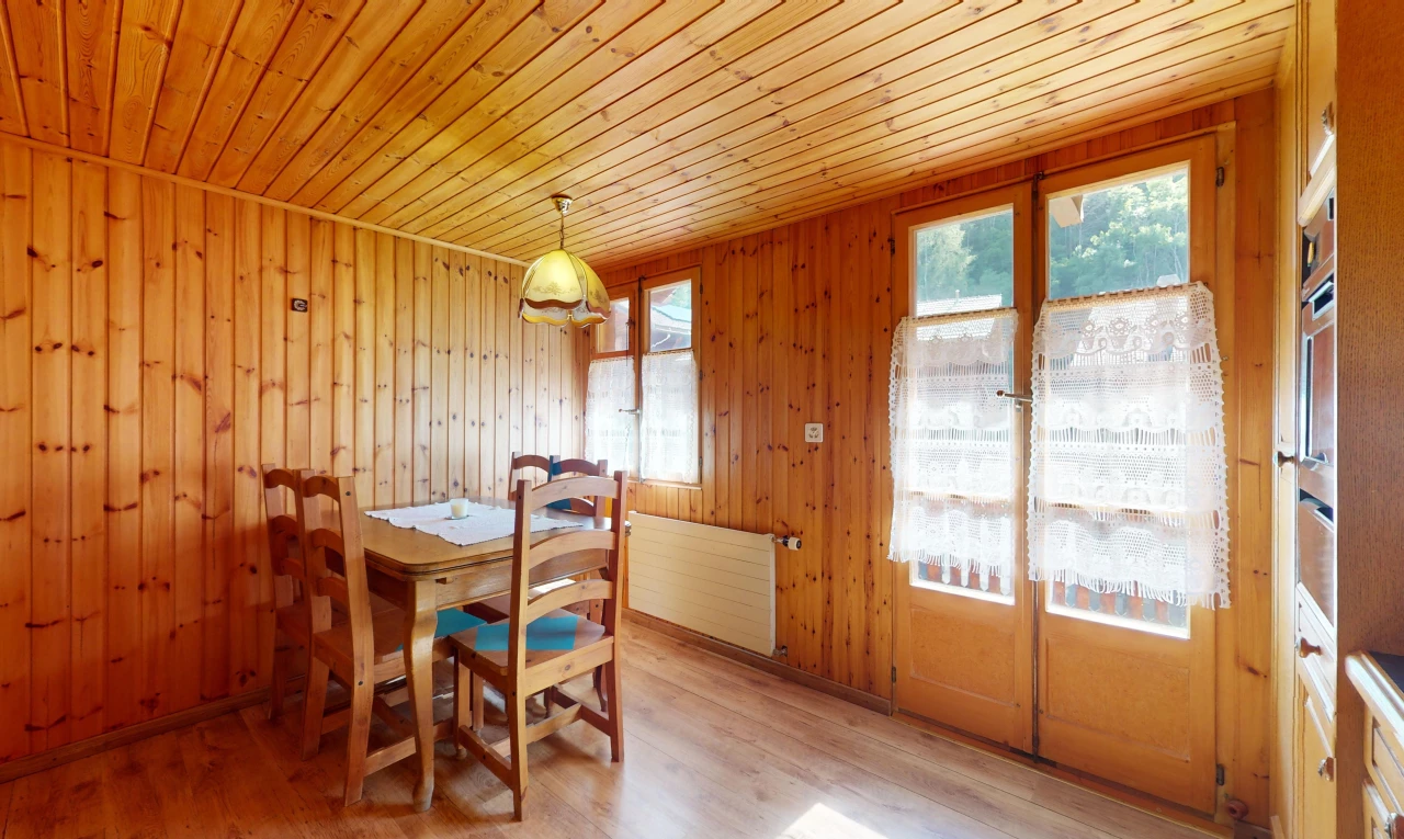 salle à manger avec plancher de bois, mur en bois, lumière naturelle, et plafond de bois