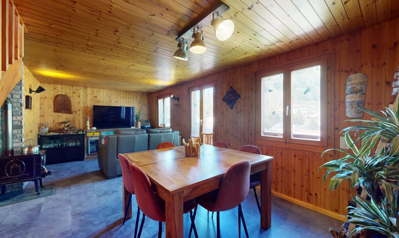 salle à manger avec plafond de bois, mur en bois, télévision, et lumière naturelle
