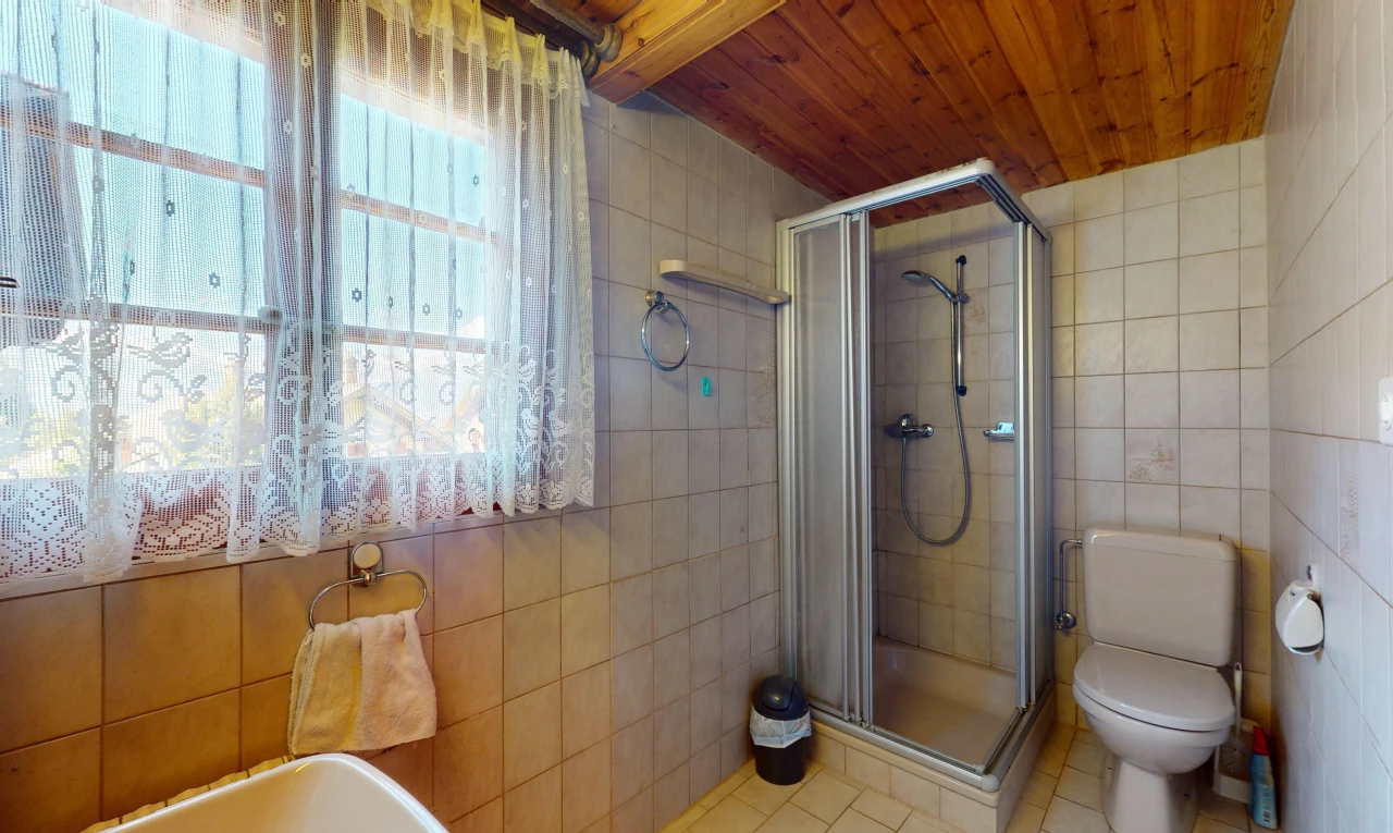 salle de bains avec plafond de bois, carrelage, douche, et lumière naturelle