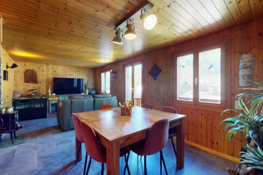 salle à manger avec plafond de bois, mur en bois, télévision, et lumière naturelle