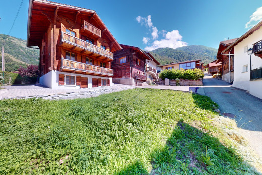 exterior space with a balcony, a yard, and a mountain view
