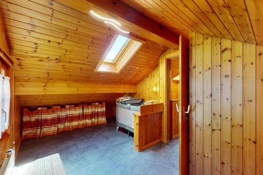 chambre avec mur en bois, plafond de bois, lucarne, plafond bas, et plafond voûté