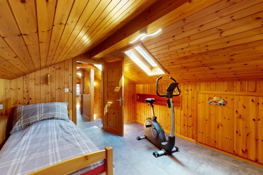 gym avec lucarne, plafond voûté, mur en bois, et plafond de bois